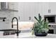 Modern kitchen with white cabinets, stainless steel appliances, and a stylish brick backsplash at 1111 E Peach Tree Dr, Chandler, AZ 85249