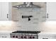 Close up on Wolf stovetop in new kitchen with stainless steel hood, white cabinets and pot filler faucet at 1111 E Peach Tree Dr, Chandler, AZ 85249