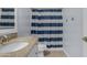Well-lit bathroom with granite countertop and blue striped shower curtain at 1719 E Dana Ave, Mesa, AZ 85204