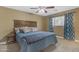 Bedroom features wood headboard, ceiling fan, and cozy, inviting ambiance at 1719 E Dana Ave, Mesa, AZ 85204