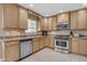 Well-lit kitchen featuring stainless steel appliances, light wood cabinets, and functional layout at 1719 E Dana Ave, Mesa, AZ 85204