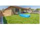 Spacious backyard features an inflatable pool, trampoline, turf, and a covered patio at 17296 W Molly Ln, Surprise, AZ 85387