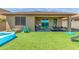 Spacious backyard with an inflatable pool, covered patio, turf and play set at 17296 W Molly Ln, Surprise, AZ 85387