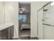 Bathroom with shower and view into the large bedroom with ceiling fan and a window at 17296 W Molly Ln, Surprise, AZ 85387