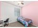 Bright bedroom boasts a ceiling fan, plush carpet, and a cozy bed with vibrant bedding at 17296 W Molly Ln, Surprise, AZ 85387