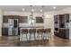 Modern kitchen boasts stainless steel appliances, a kitchen island with seating, and pendant lighting at 17296 W Molly Ln, Surprise, AZ 85387