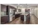 Modern kitchen featuring stainless steel appliances, dark cabinetry, and an island with barstool seating at 17296 W Molly Ln, Surprise, AZ 85387