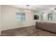 Bright living room with a comfortable couch, wood-look floors, and large windows at 17296 W Molly Ln, Surprise, AZ 85387