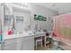 Bright bathroom featuring a vanity with makeup area and a shower with a princess themed curtain at 17935 W Louise Dr, Surprise, AZ 85387