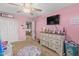 Pink bedroom featuring a TV on the wall, a dresser, a closet and a door at 17935 W Louise Dr, Surprise, AZ 85387