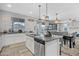 Kitchen island featuring granite countertops, stainless steel appliances, gray walls and view to the living room at 17935 W Louise Dr, Surprise, AZ 85387