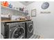 Modern laundry room with front-load washer and dryer and useful shelf space at 17935 W Louise Dr, Surprise, AZ 85387
