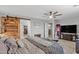 Main bedroom with a sliding barn door that leads to the bathroom and a ceiling fan at 17935 W Louise Dr, Surprise, AZ 85387