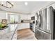 Well-lit kitchen with stainless steel refrigerator, granite countertops, and modern appliances at 18644 N 21St St, Phoenix, AZ 85024