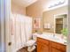 Cozy bathroom with wood cabinets, shower with curtain, and tasteful decor at 22986 S 208Th St, Queen Creek, AZ 85142