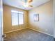 Bright, carpeted bedroom with ceiling fan, large window, and minimalist decor at 22986 S 208Th St, Queen Creek, AZ 85142