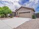 Exterior view of the property showcasing a two-car garage and well-maintained yard at 22986 S 208Th St, Queen Creek, AZ 85142