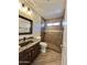 Accessible bathroom featuring a stylish vanity, granite countertop, step in shower with grab bars and neutral tiling at 2549 E Desert Trumpet Rd, Phoenix, AZ 85048