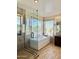 Modern bathroom showcasing a glass shower and soaking tub with window views at 2549 E Desert Trumpet Rd, Phoenix, AZ 85048