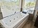 Close up of white soaking tub with view out of a window at 2549 E Desert Trumpet Rd, Phoenix, AZ 85048