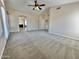 Open-concept living room with ceiling fan, window, and view into kitchen area at 2549 E Desert Trumpet Rd, Phoenix, AZ 85048