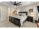 The primary bedroom with a ceiling fan, king bed with black frame, carpet floor, and neutral walls at 25947 W Oraibi Dr, Buckeye, AZ 85396