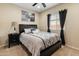 Comfortable bedroom featuring neutral walls, large window, ceiling fan and sleek, modern furnishings at 25947 W Oraibi Dr, Buckeye, AZ 85396