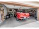 Garage interior featuring a red Tacoma and tools, highlighting parking and storage capabilities at 25947 W Oraibi Dr, Buckeye, AZ 85396