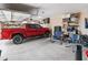 A spacious garage with a red truck and a set of rocking chairs at 25947 W Oraibi Dr, Buckeye, AZ 85396