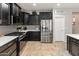 Modern kitchen showcasing dark cabinets, stainless steel appliances, a gas range, and designer tile backsplash at 25947 W Oraibi Dr, Buckeye, AZ 85396