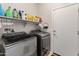 Clean laundry room with modern washer and dryer, and shelf space for detergents and cleaning supplies at 25947 W Oraibi Dr, Buckeye, AZ 85396