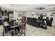 An open-concept living area showcasing a dining table, kitchen island, and comfortable leather recliners at 25947 W Oraibi Dr, Buckeye, AZ 85396