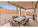 Relaxing covered patio features an outdoor dining set and overlooks a spacious backyard, perfect for entertaining at 25947 W Oraibi Dr, Buckeye, AZ 85396