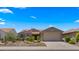 Attractive single-story home showcasing a tile roof, desert landscaping, and a paved driveway at 27057 W Tonopah Dr, Buckeye, AZ 85396