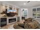 Comfortable living room with a fireplace, built-in shelving, and a view to an office space at 27057 W Tonopah Dr, Buckeye, AZ 85396