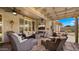 Relaxing covered patio with comfortable seating, ceiling fan, and outdoor entertainment area at 27057 W Tonopah Dr, Buckeye, AZ 85396