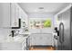 Bright and modern kitchen with white cabinets, stainless steel appliances, and a window overlooking the backyard at 2923 N 81St Pl, Scottsdale, AZ 85251