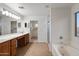 Well-lit bathroom offers double sinks, vanity, soaking tub, and convenient closet access at 3022 N Lainey Ln, Buckeye, AZ 85396