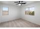 Carpeted bedroom with a ceiling fan and bright windows offering neighborhood views at 3022 N Lainey Ln, Buckeye, AZ 85396