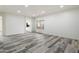 Bright living room with wood-look tile flooring, recessed lighting, and a view into the kitchen at 3022 N Lainey Ln, Buckeye, AZ 85396