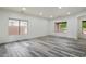 Spacious living area featuring wood-look tile flooring, large windows, and recessed lighting at 3022 N Lainey Ln, Buckeye, AZ 85396