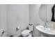 Modern powder room with pedestal sink, round mirror, and wood-look tile floor at 32366 N 133Rd Ln, Peoria, AZ 85383