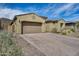 Attractive single-story house with a brick driveway, attached garage and desert landscaping against a bright blue sky at 32366 N 133Rd Ln, Peoria, AZ 85383