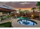Secluded backyard oasis featuring a pool, spa, gazebo, desert landscaping, and an umbrella table at 3628 E Meadowview Dr, Gilbert, AZ 85298