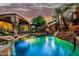 Serene backyard oasis featuring a sparkling pool, stone waterfall feature, and lush landscaping at 3628 E Meadowview Dr, Gilbert, AZ 85298