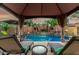 View of pool from shady gazebo with poolside lounge chairs and coffee table at 3628 E Meadowview Dr, Gilbert, AZ 85298