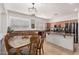 Open kitchen with wooden cabinets, a glass table with chairs, and stainless steel appliances at 3628 E Meadowview Dr, Gilbert, AZ 85298