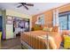 This bedroom features an orange accent wall, a ceiling fan, and a well-stocked closet at 36801 N Long Rifle Rd, Carefree, AZ 85377