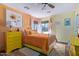 Bright bedroom with an orange accent wall, white metal bed, and yellow dresser at 36801 N Long Rifle Rd, Carefree, AZ 85377