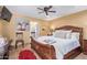 Bedroom featuring wood floors, ceiling fan, television, and connecting door to the bathroom at 36801 N Long Rifle Rd, Carefree, AZ 85377